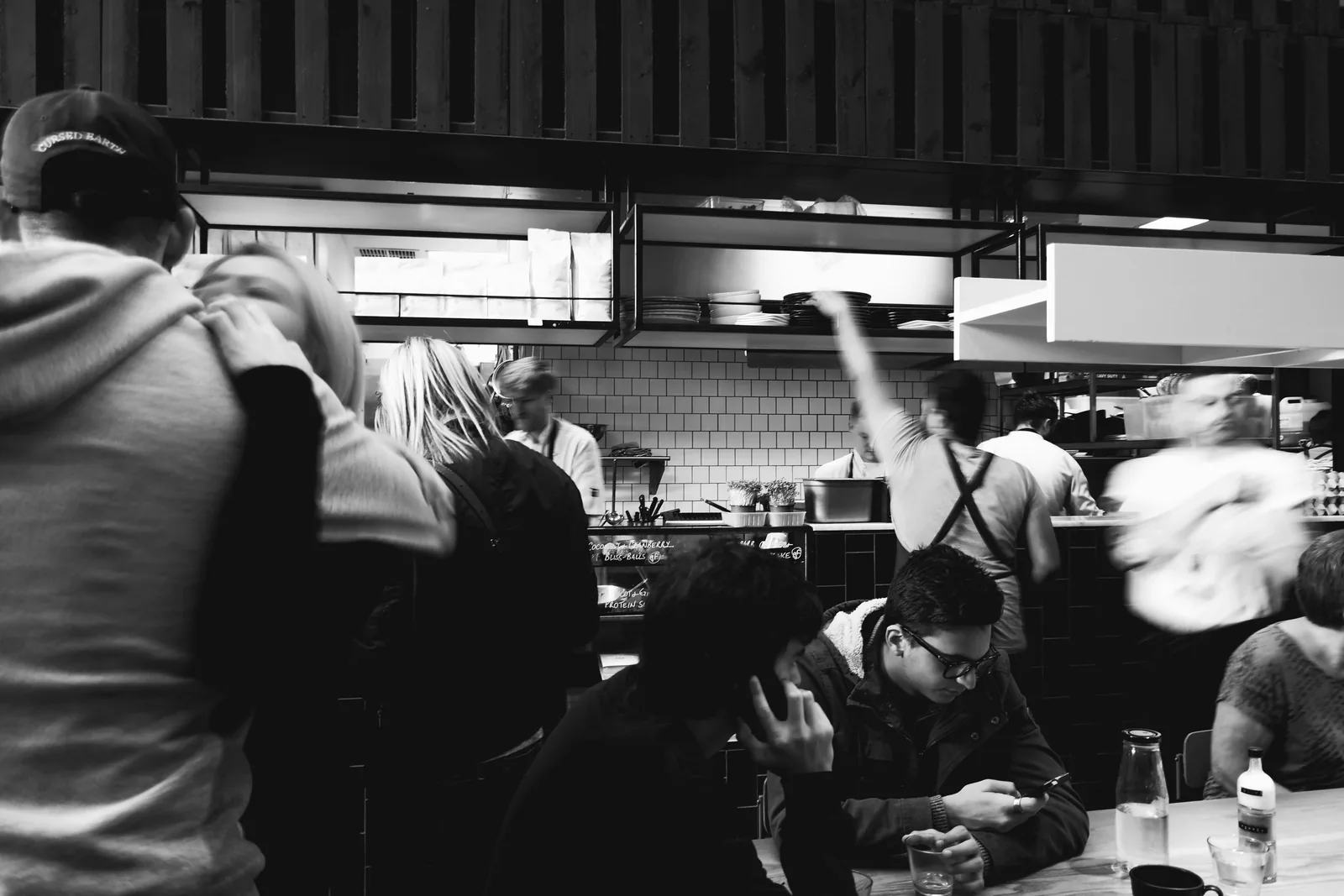 Clienti e personale in un locale animato, fotografia in bianco e nero